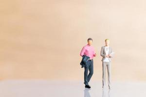 Miniature businesspeople standing and copy space for text photo