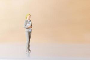Miniature businesswoman standing and copy space for text photo