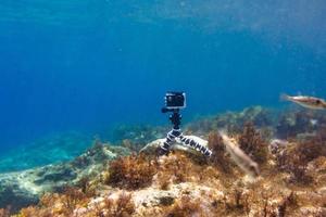 usando la cámara en una caja impermeable en un trípode para hacer fotos y videos