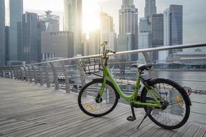 Green bike in public park and modern view business building background and sky view landscape of commercial building in central city photo