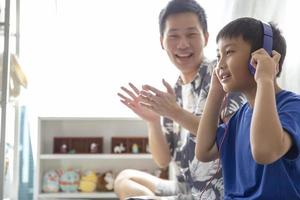 Happy family while using headphones to listen to music and smiling, enjoy spending time together at home photo