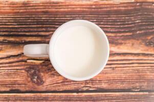 A cup of milk on a wooden table photo