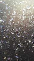 Foil pieces on black background with multi-colored shine. Abstract fashion stock macro photo. photo