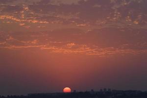 colorido atardecer en un cielo nublado sobre un cuerpo de agua foto