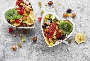 Two heart-shaped bowls of dried fruit and nuts photo