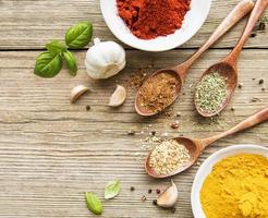 Spices on a wooden table in bowls and spoons photo