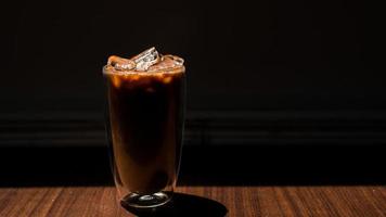 Glass of coffee with milk on a wooden table photo