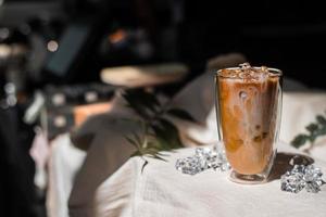 Close-up vaso de café helado con leche sobre la mesa foto