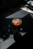 Close-up glass of iced coffee with milk on the table photo