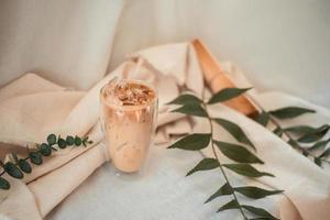 Close-up vaso de café helado con leche sobre la mesa foto
