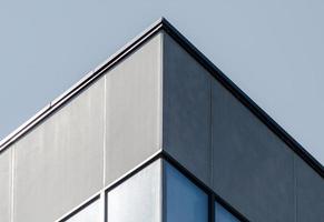 Corner of a gray concrete building with windows photo