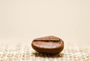 Un grano de café sobre un fondo beige macro estera cerrar foto