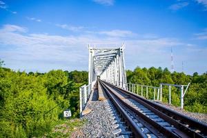 Hermoso puente ferroviario sobre un fondo de vegetación y cielo azul, perspectiva foto