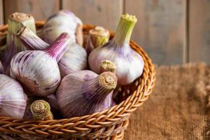 Fresh garlic on a wooden background. Fragrant spice for cooking. photo