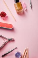 A set of tools for manicure and nail care on pink background. Workplace in a beauty salon. Place for text.
