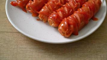 Brochette de saucisse frite avec du ketchup sur plaque blanche video