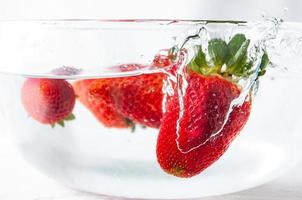 Grupo de fresas en un recipiente con agua foto