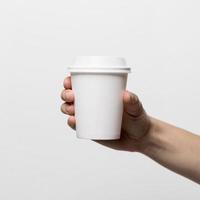 mano que sostiene la taza de café con leche de cerca foto