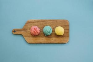 Concepto de helado con tres bolas sobre fondo azul.