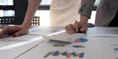 Close-up of professionals looking over graphs photo