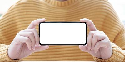 persona sosteniendo un teléfono maqueta horizontalmente foto