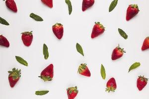 Bright juicy strawberries with green leaves on white background