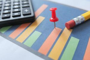 Financial graph with calculator and notepad on table photo
