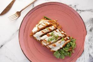 Grilled chicken, rice and fresh vegetable salad on table photo