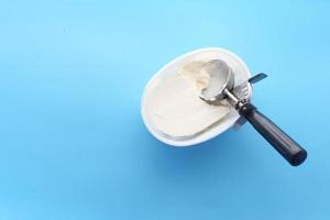 helado y cuchara sobre un fondo azul. foto