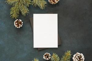 Blank paper surrounded by pine leaves and cones photo