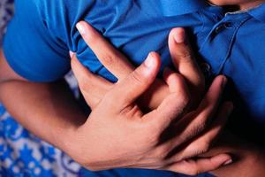 Person clutching chest suffering a heart attack photo