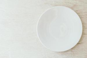 plato blanco sobre fondo blanco de madera foto