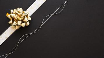 Decorative ribbon bow and silver string on black background
