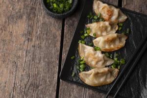 Flat lay of Asian dumpling dish with herbs and copy space photo