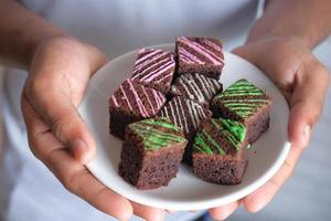 Person holding a plate of brownies photo