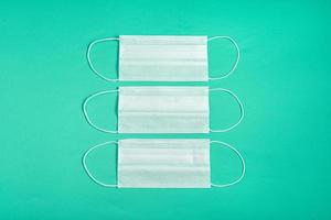 Surgical mask over minimalist green background photo