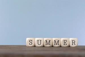 Summer word written in wooden cube on wooden table photo