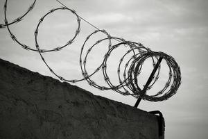 Barbed wire on the wall in black and white photo