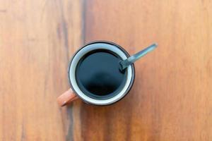 Cup of brewed black coffe on the wooden table photo