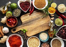 Various spices in a bowls and empty cutting board photo