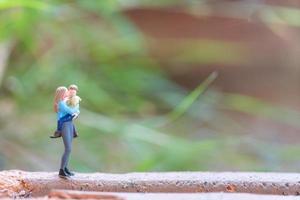 gente en miniatura, madre sosteniendo a su lindo bebé, concepto de feliz día de la madre foto