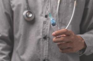 The doctor holds a syringe to treat a sick patient