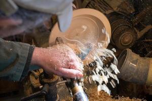 Making a wooden bowl on a lathe in an old small workshop photo