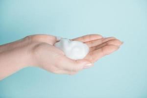 Soap foam in the hand on a blue background photo