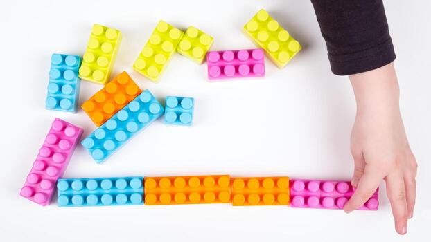 Child plays with constructor on white background photo