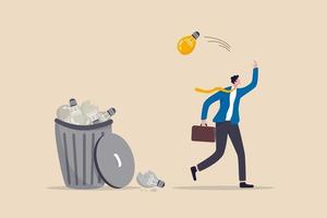 ideas inviables desperdiciadas, fracaso empresarial o demasiados proyectos abandonados, el empresario frustrado tira la idea de la bombilla en una idea llena de basura en la canasta.