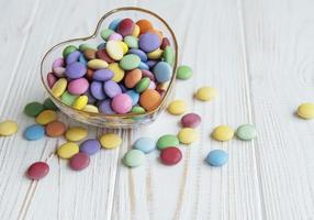 cuenco con caramelos de grageas multicolores foto