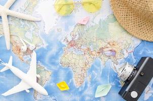 World map with camera, toy plane and starfish photo