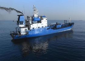 Aerial view of the blue ship on the surface of the sea. photo