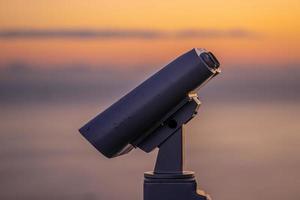 binoculares para turistas en el fondo de la puesta de sol foto